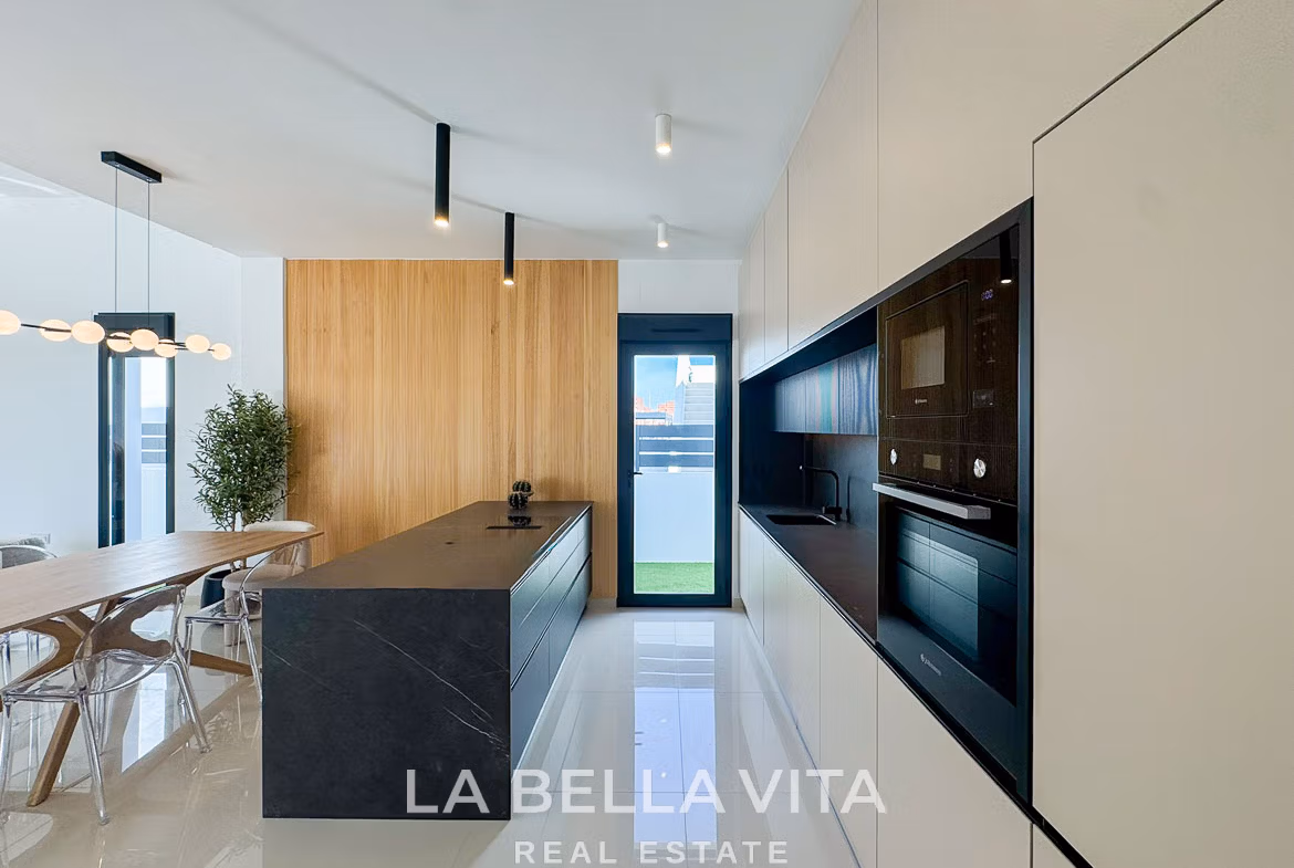 Sleek modern kitchen with black island and elegant wood paneling in a luxury 3-bedroom villa in San Miguel de Salinas.