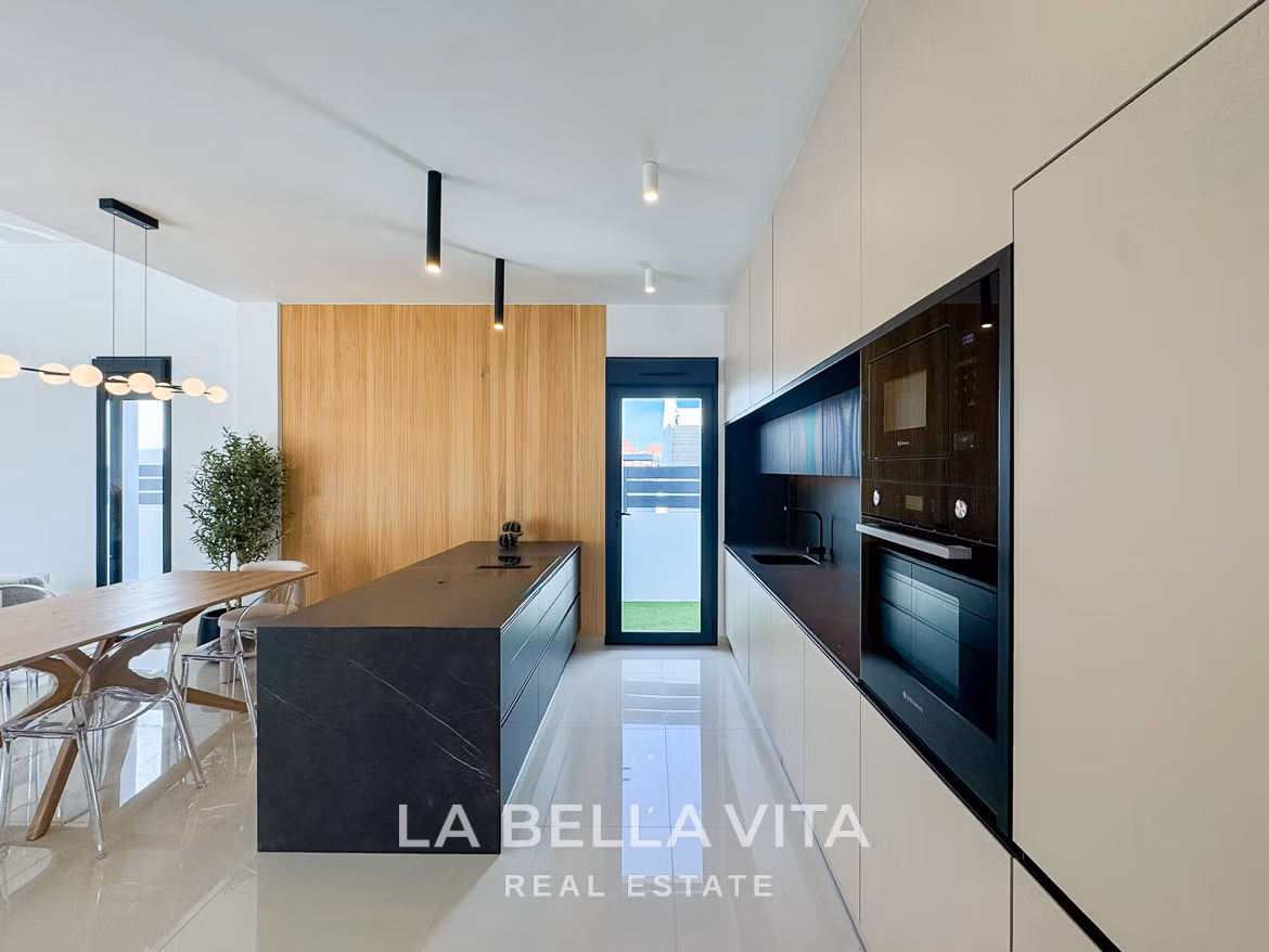 Sleek modern kitchen with black island and elegant wood paneling in a luxury 3-bedroom villa in San Miguel de Salinas.