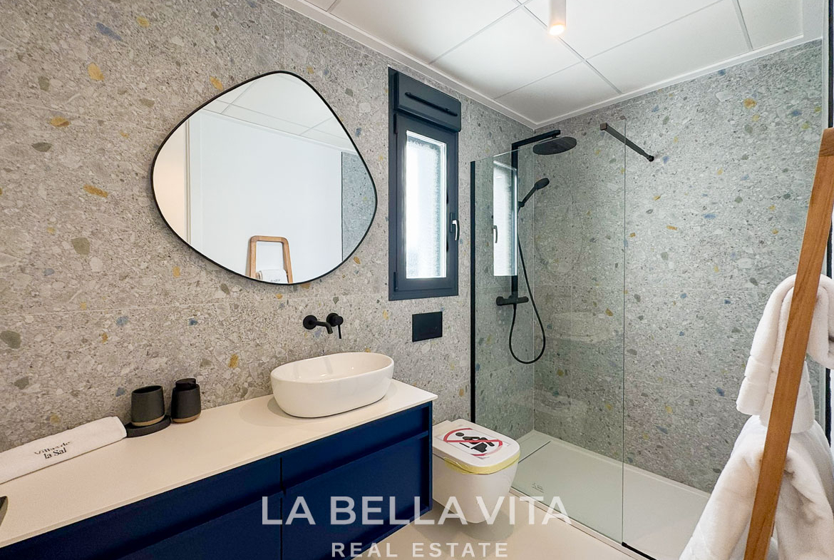 Modern 3-bedroom villa bathroom in San Miguel de Salinas with sleek stone walls, elegant black fixtures, and bright natural light.