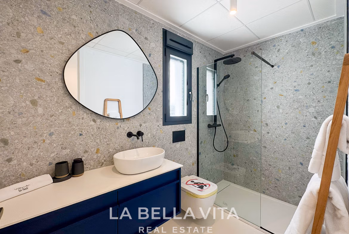 Modern 3-bedroom villa bathroom in San Miguel de Salinas with sleek stone walls, elegant black fixtures, and bright natural light.
