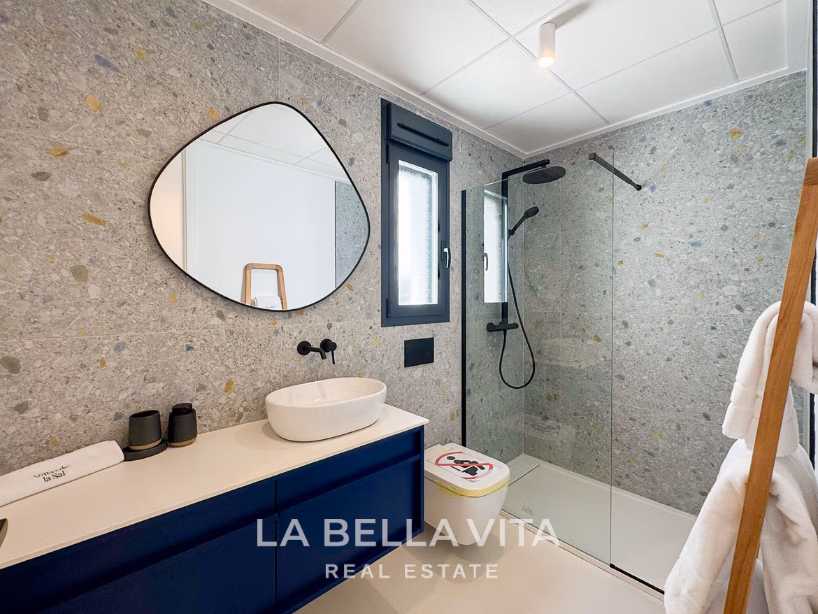 Modern 3-bedroom villa bathroom in San Miguel de Salinas with sleek stone walls, elegant black fixtures, and bright natural light.