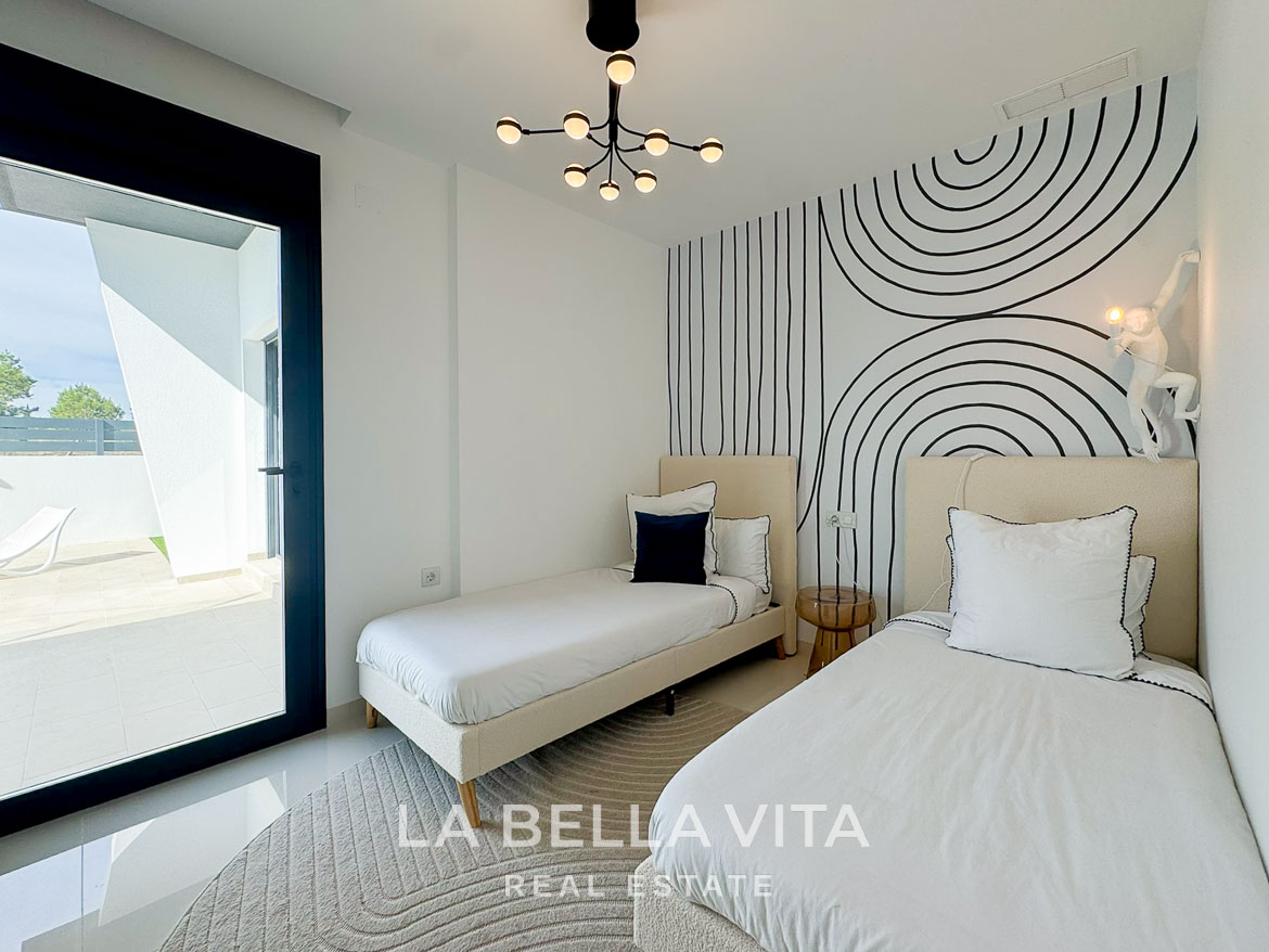 Bright modern twin bedroom with striking geometric wall art and terrace access in a new 3-bedroom villa, San Miguel de Salinas