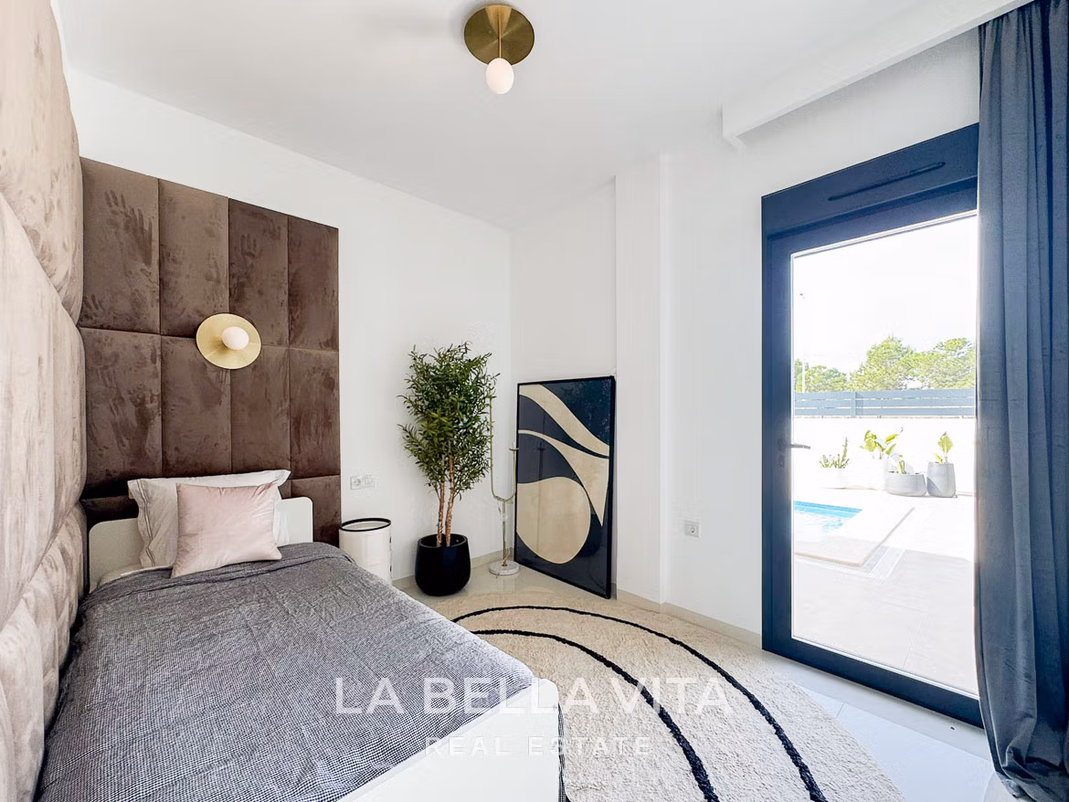 Bright modern bedroom with plush headboard, elegant decor, and sliding door opening to private pool in San Miguel de Salinas villa.