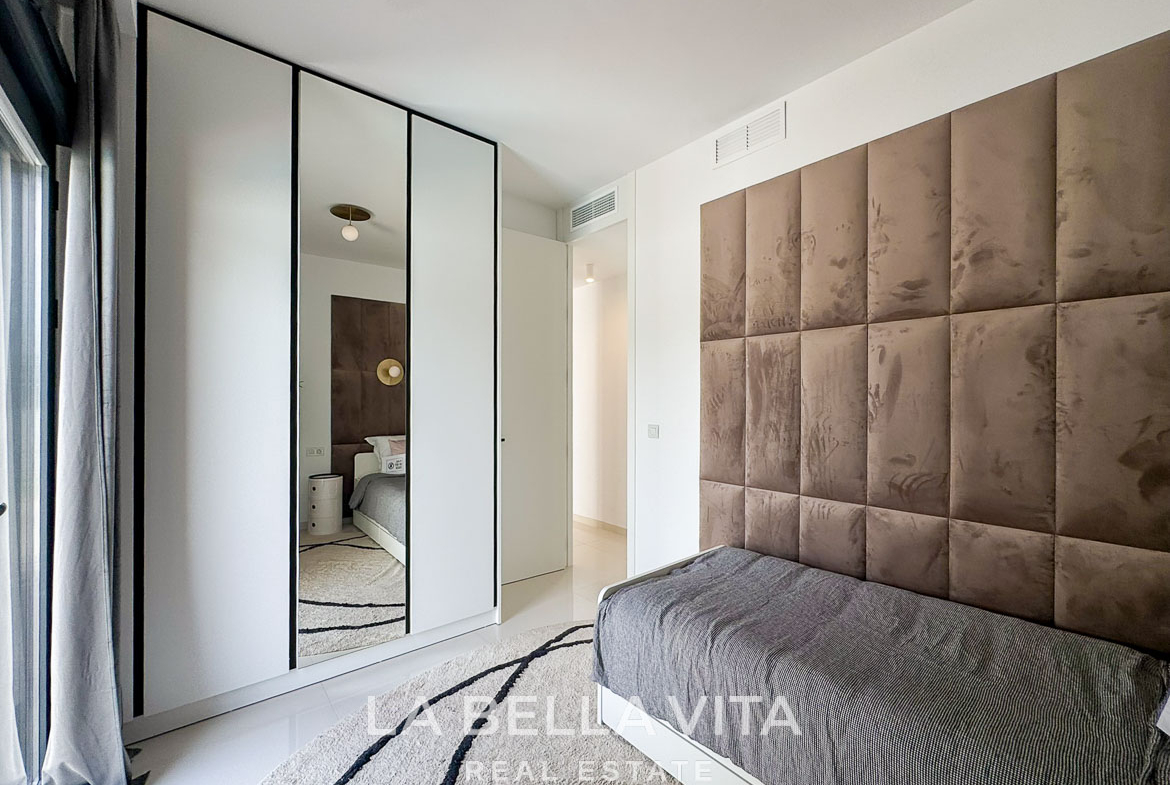 Bright modern bedroom with plush upholstered headboard and sleek wardrobe in 3-bedroom villa in San Miguel de Salinas