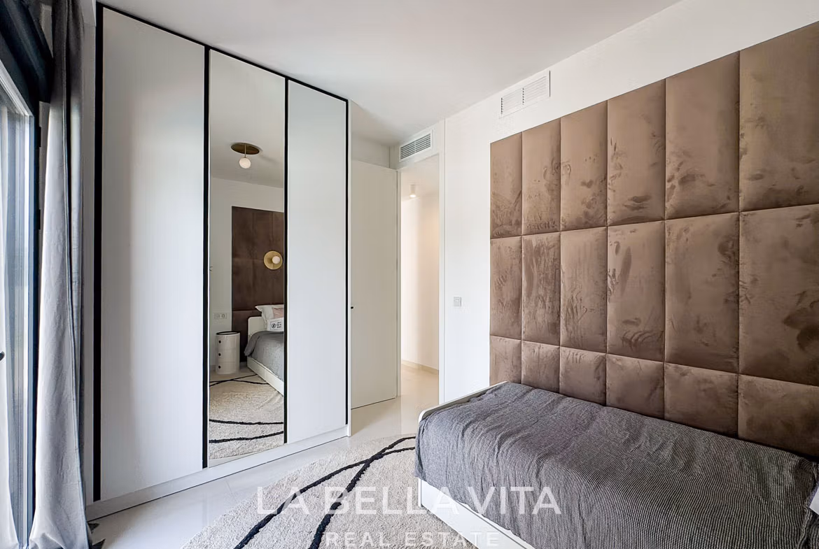 Bright modern bedroom with plush upholstered headboard and sleek wardrobe in 3-bedroom villa in San Miguel de Salinas
