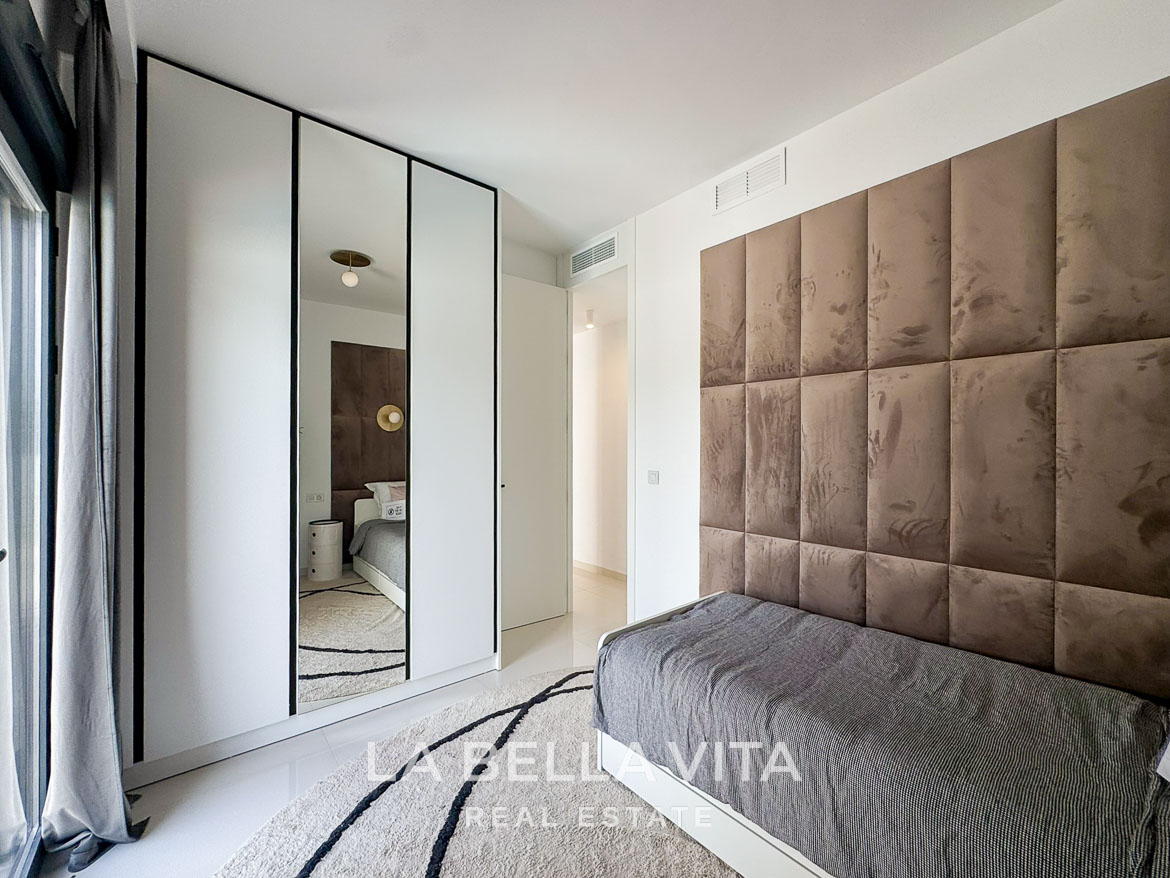 Bright modern bedroom with plush upholstered headboard and sleek wardrobe in 3-bedroom villa in San Miguel de Salinas