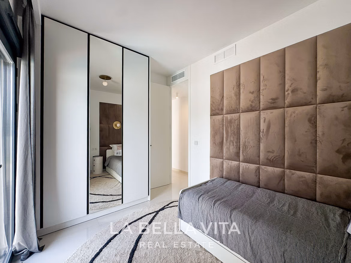 Bright modern bedroom with plush upholstered headboard and sleek wardrobe in 3-bedroom villa in San Miguel de Salinas