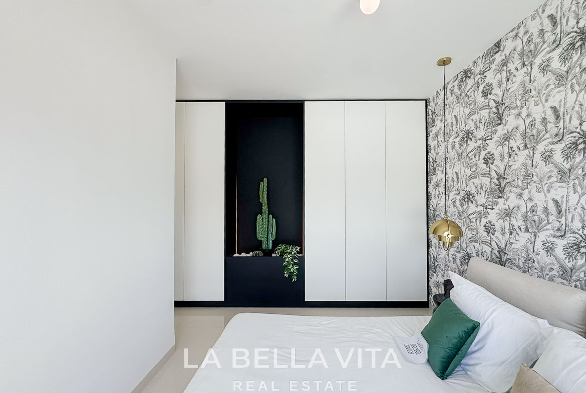 Bright modern bedroom with elegant wallpaper and built-in wardrobes in a sleek 3-bedroom villa in San Miguel de Salinas