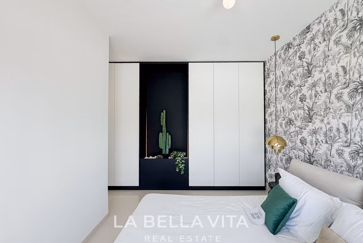 Bright modern bedroom with elegant wallpaper and built-in wardrobes in a sleek 3-bedroom villa in San Miguel de Salinas