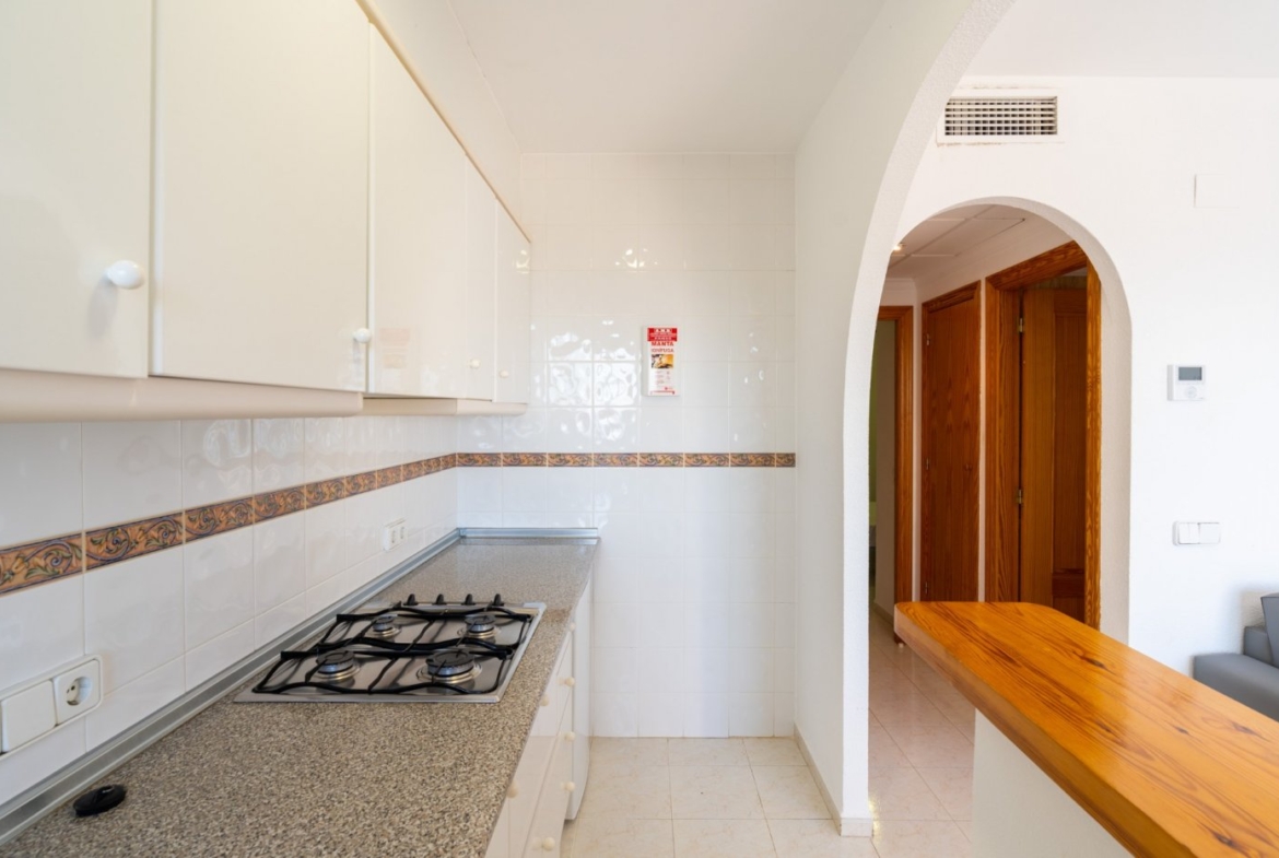 Bright, modern kitchen with granite countertops and sleek cabinetry in a top floor bungalow apartment in Calpe.