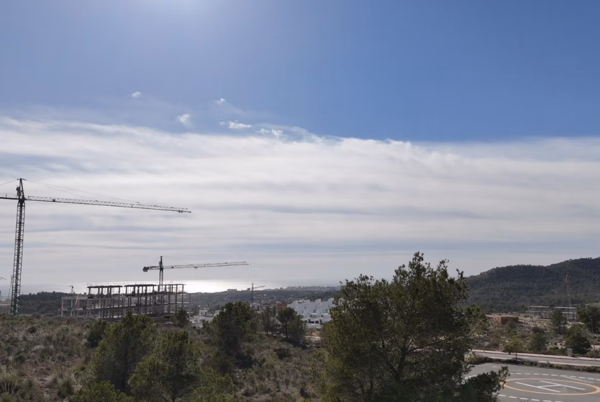 Tourist-Licensed-New-Build-Apartments-in-Finestrat-Investment-Opportunity-Near-Golf-and-Benidorm-10 Panoramic sea view with lush greenery and construction cranes near the smart new build 1 bedroom apartment in Finestrat, Benidorm