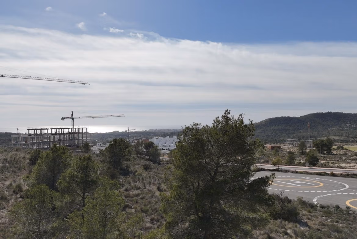 Tourist-Licensed-New-Build-Apartments-in-Finestrat-Investment-Opportunity-Near-Golf-and-Benidorm-11 Panoramic view of landscaped hills and construction cranes near new 1-bedroom tourist licensed apartment in Finestrat, Benidorm
