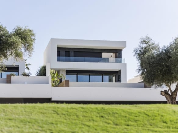 Front view of a two-storey villa with glass balcony beside La Finca Golf in Algorfa, Alicante