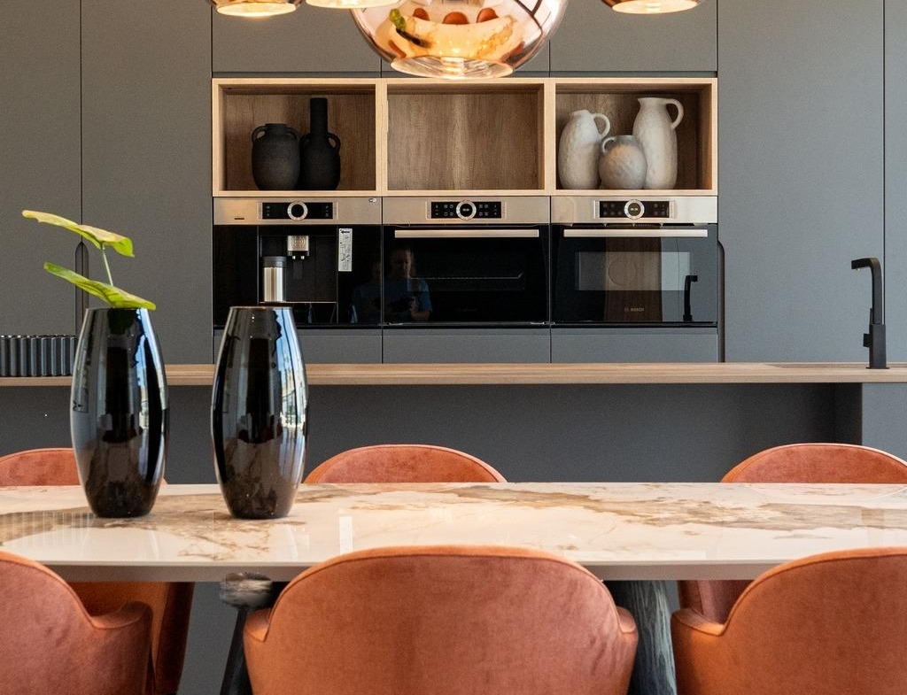 Modern bespoke kitchen in Ciudad Quesada villa featuring sleek cabinetry, polished marble table, and warm copper pendant...
