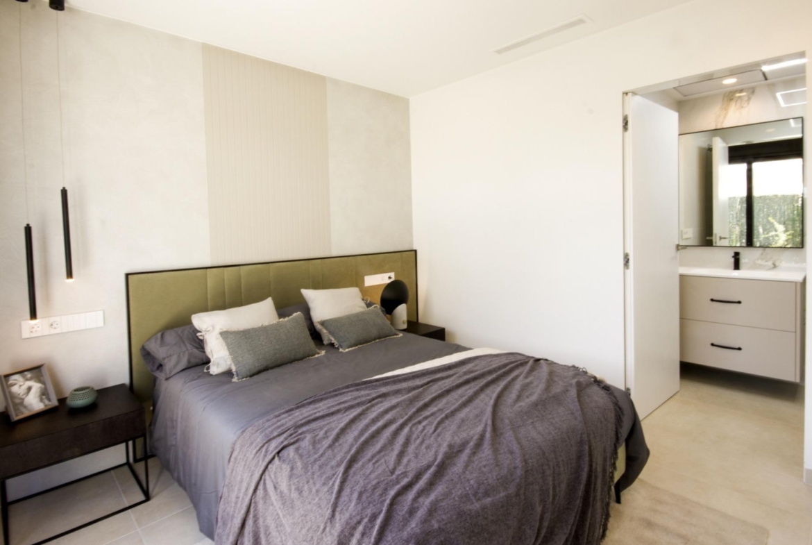 Bright modern bedroom in bespoke 3-bedroom villa in Ciudad Quesada with elegant green upholstered headboard and sleek...