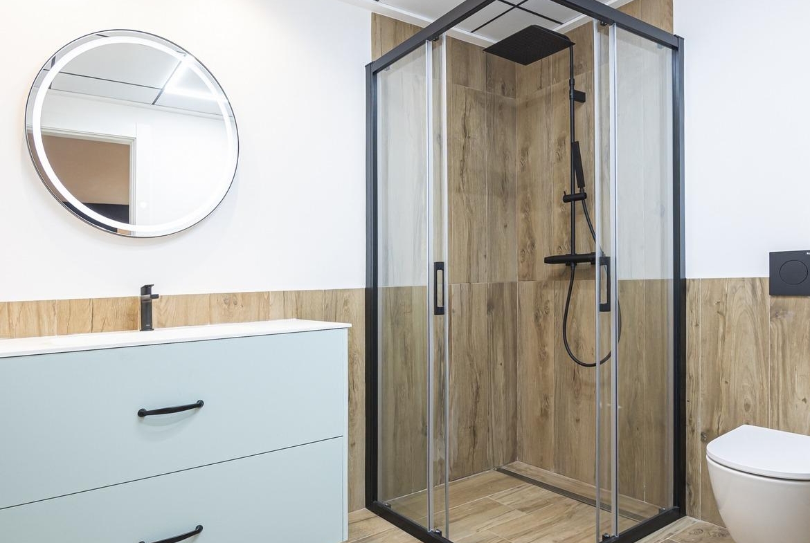 Modern bathroom with sleek black-framed shower and wood-effect tiles in bespoke 3-bedroom villa in Ciudad Quesada, Costa...
