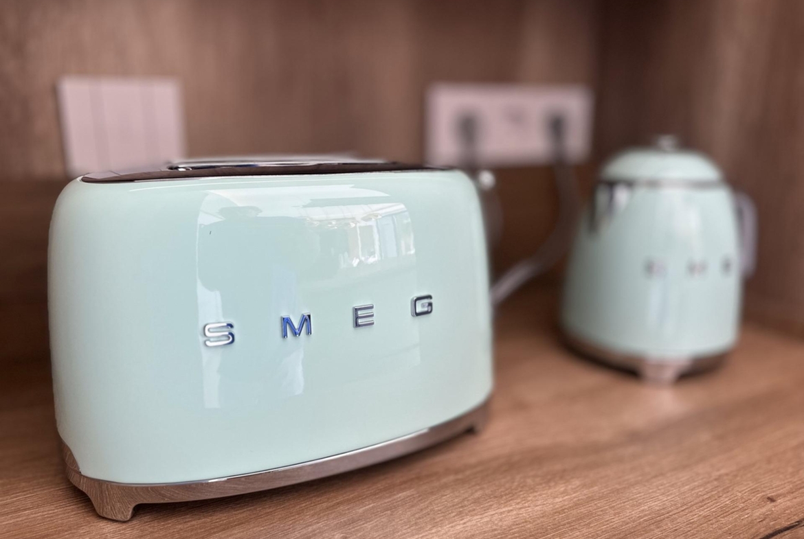 Sleek pastel blue SMEG toaster and kettle set on elegant wooden kitchen countertop in modern Ciudad Quesada villa