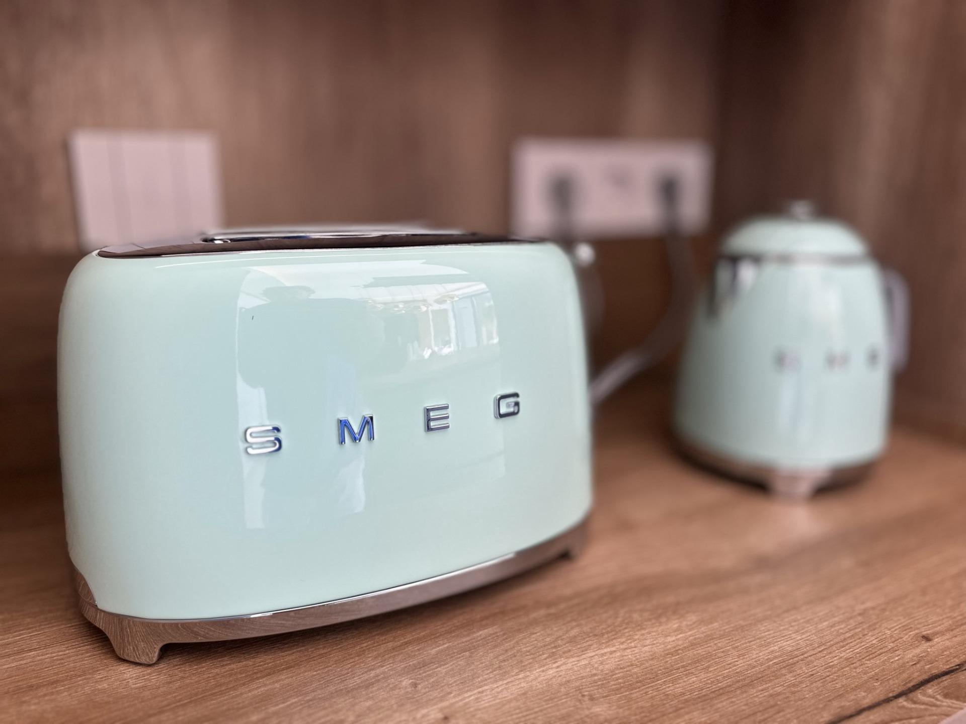 Sleek pastel blue SMEG toaster and kettle set on elegant wooden kitchen countertop in modern Ciudad Quesada villa