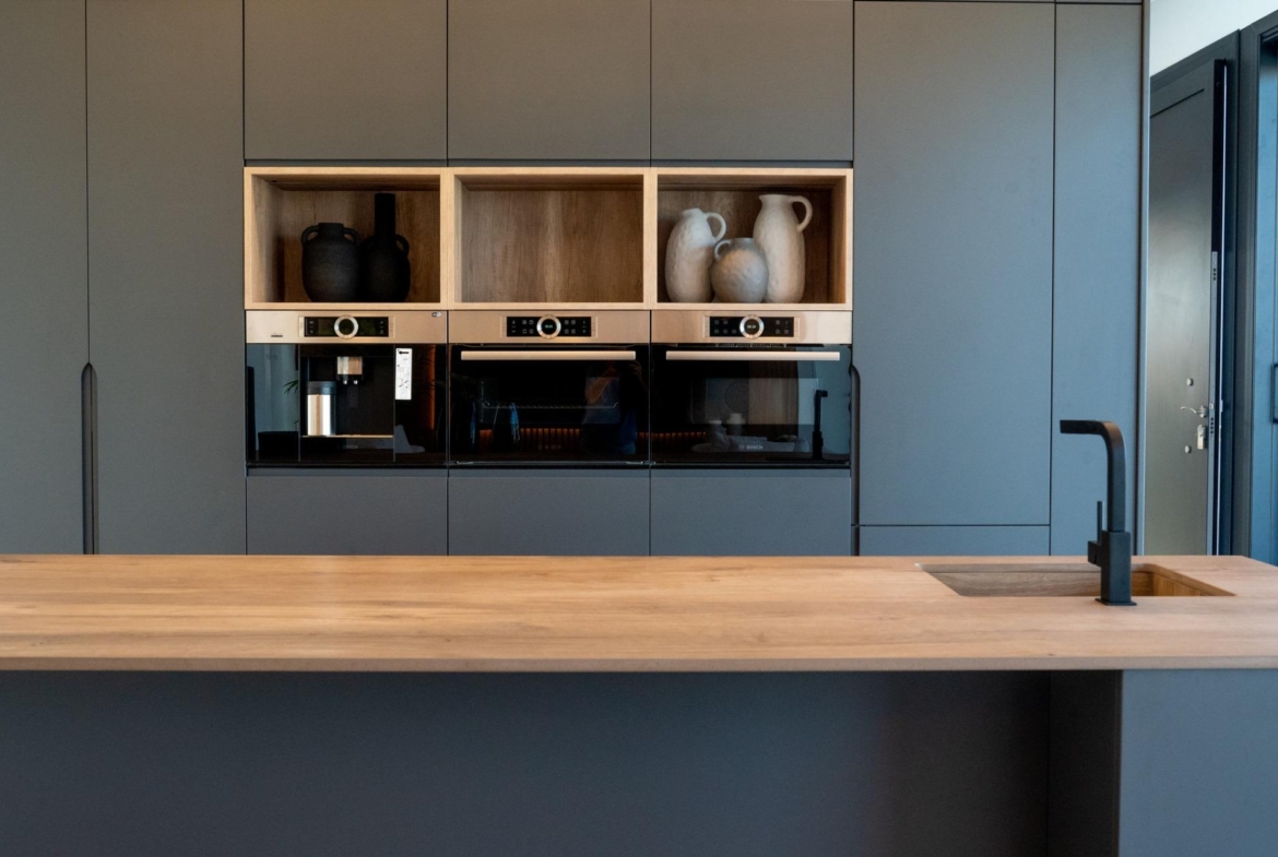Sleek modern kitchen in bespoke 3-bedroom villa, Ciudad Quesada, featuring matte cabinetry, built-in appliances, and a...