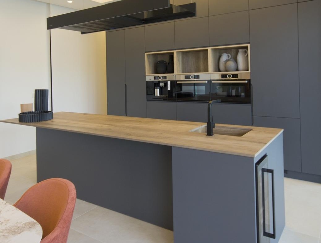 Sleek modern kitchen in bespoke 3-bedroom villa in Ciudad Quesada, featuring matte gray cabinetry and warm wood island...