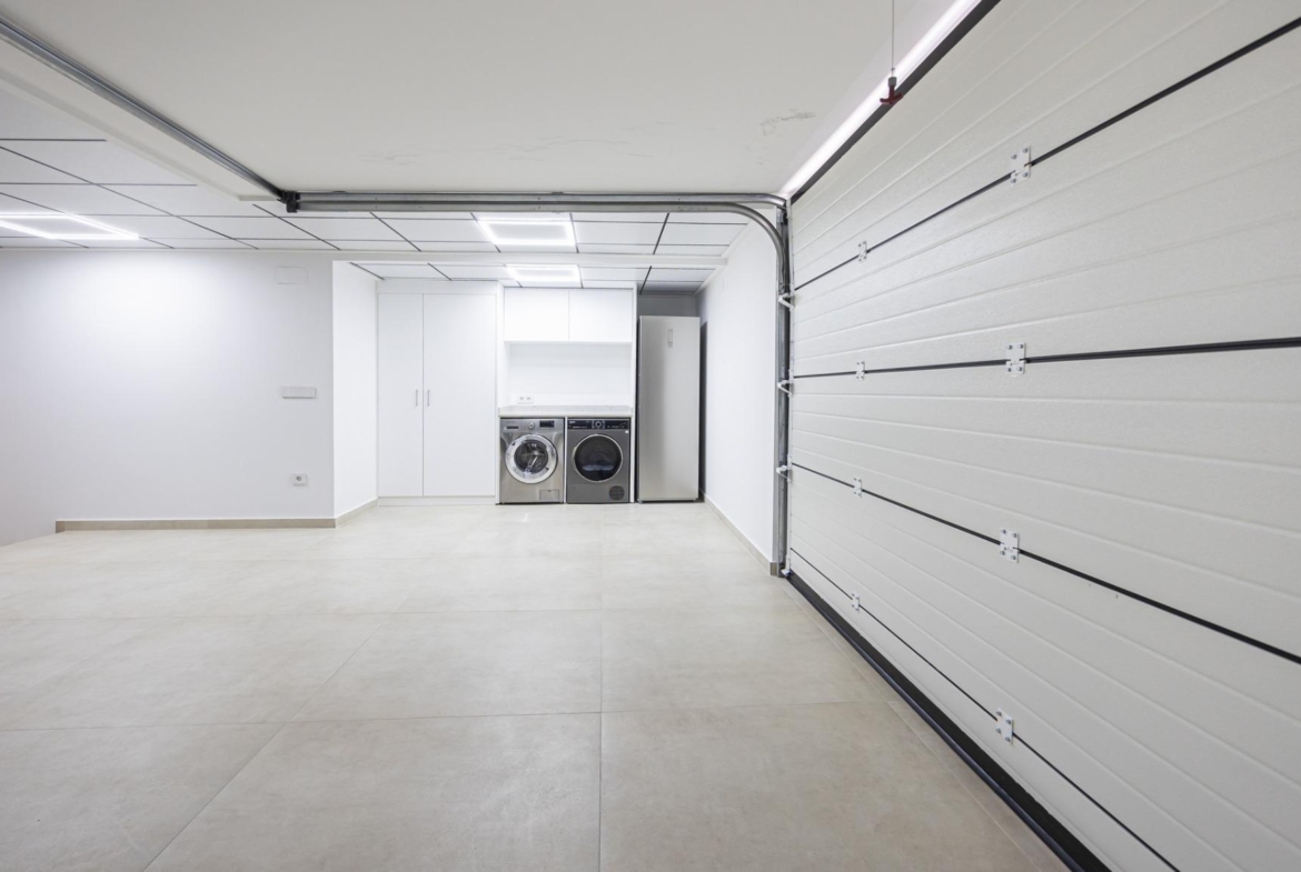 Spacious, sleek garage and laundry room with modern appliances and bright white walls in bespoke Ciudad Quesada villa.