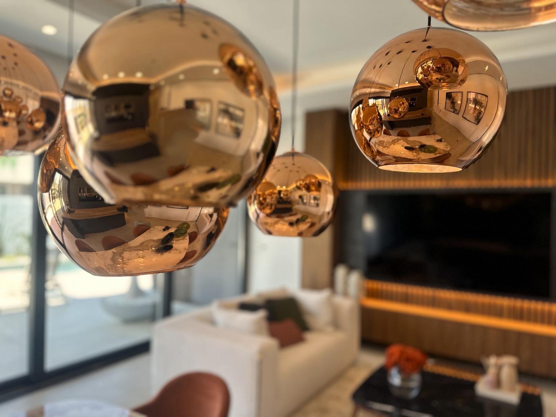 Sleek copper pendant lights reflecting the bright, modern living room of a bespoke 3-bedroom villa in Ciudad Quesada,...