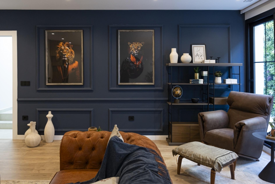 Elegant living room in bespoke new build villa in Ciudad Quesada with deep blue walls, leather armchair, and artistic...