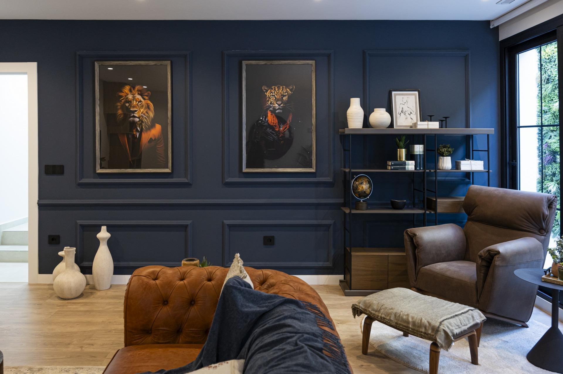 Elegant living room in bespoke new build villa in Ciudad Quesada with deep blue walls, leather armchair, and artistic...