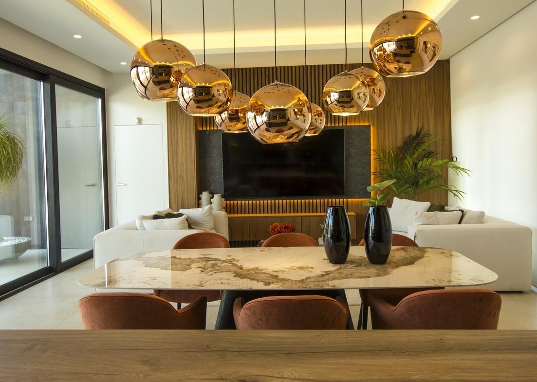 Modern bespoke 3-bedroom villa dining area in Ciudad Quesada with sleek marble table, copper pendant lights, and bright...