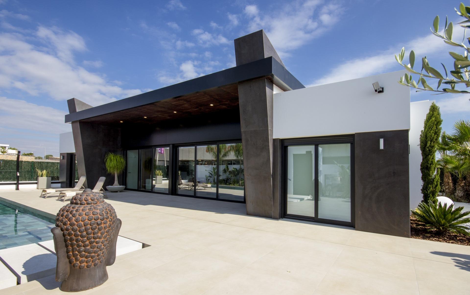 Spacious modern 3-bedroom villa in Ciudad Quesada with sleek black accents, sun-drenched patio, and poolside sculpture on...