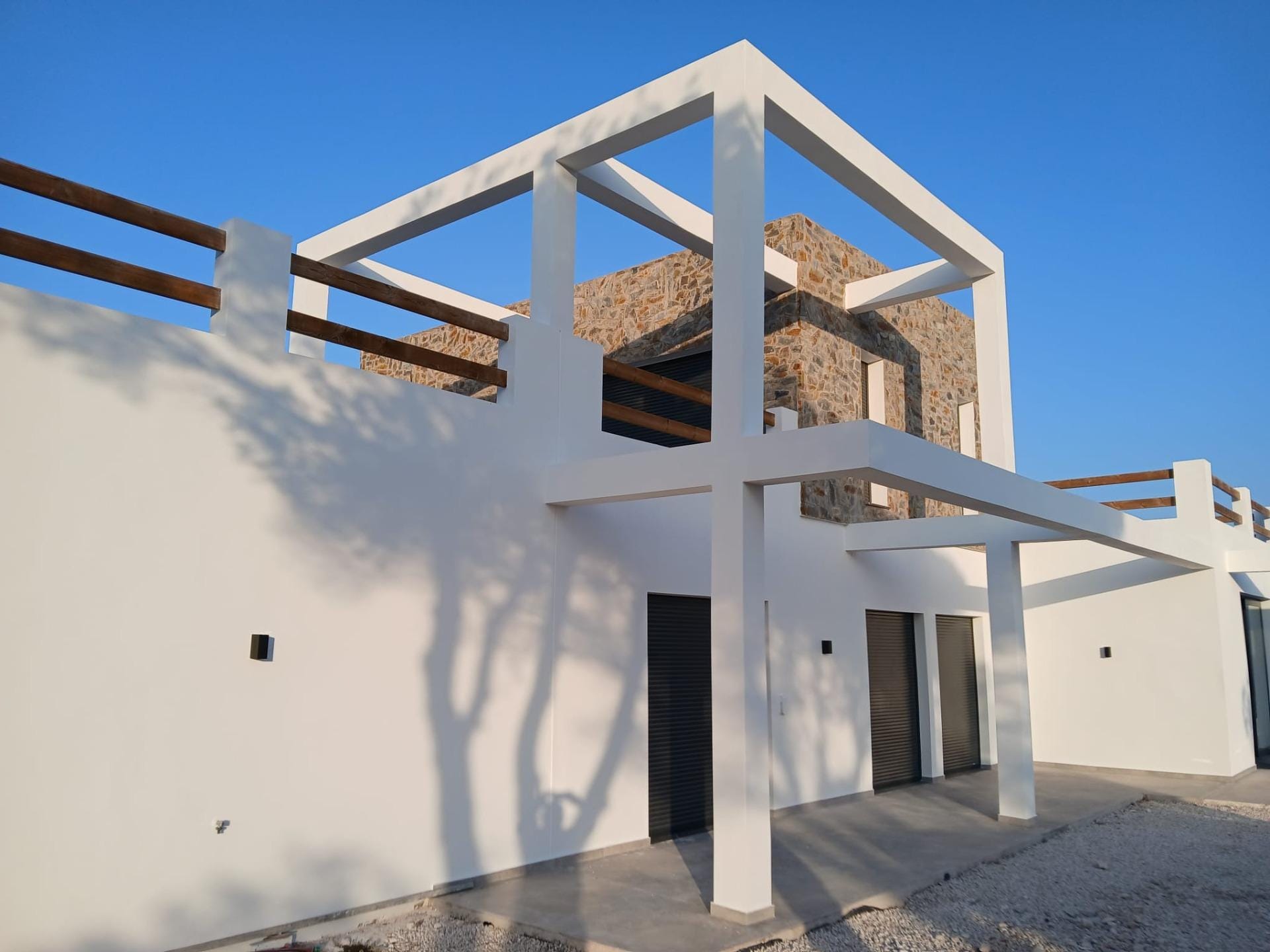 Custom-Built-New-Villas-in-Pinoso-Alicante-Spacious-Homes-in-Natural-Surroundings-1 Two-storey villa facade with terrace beams and stone cladding in Pinoso, Alicante
