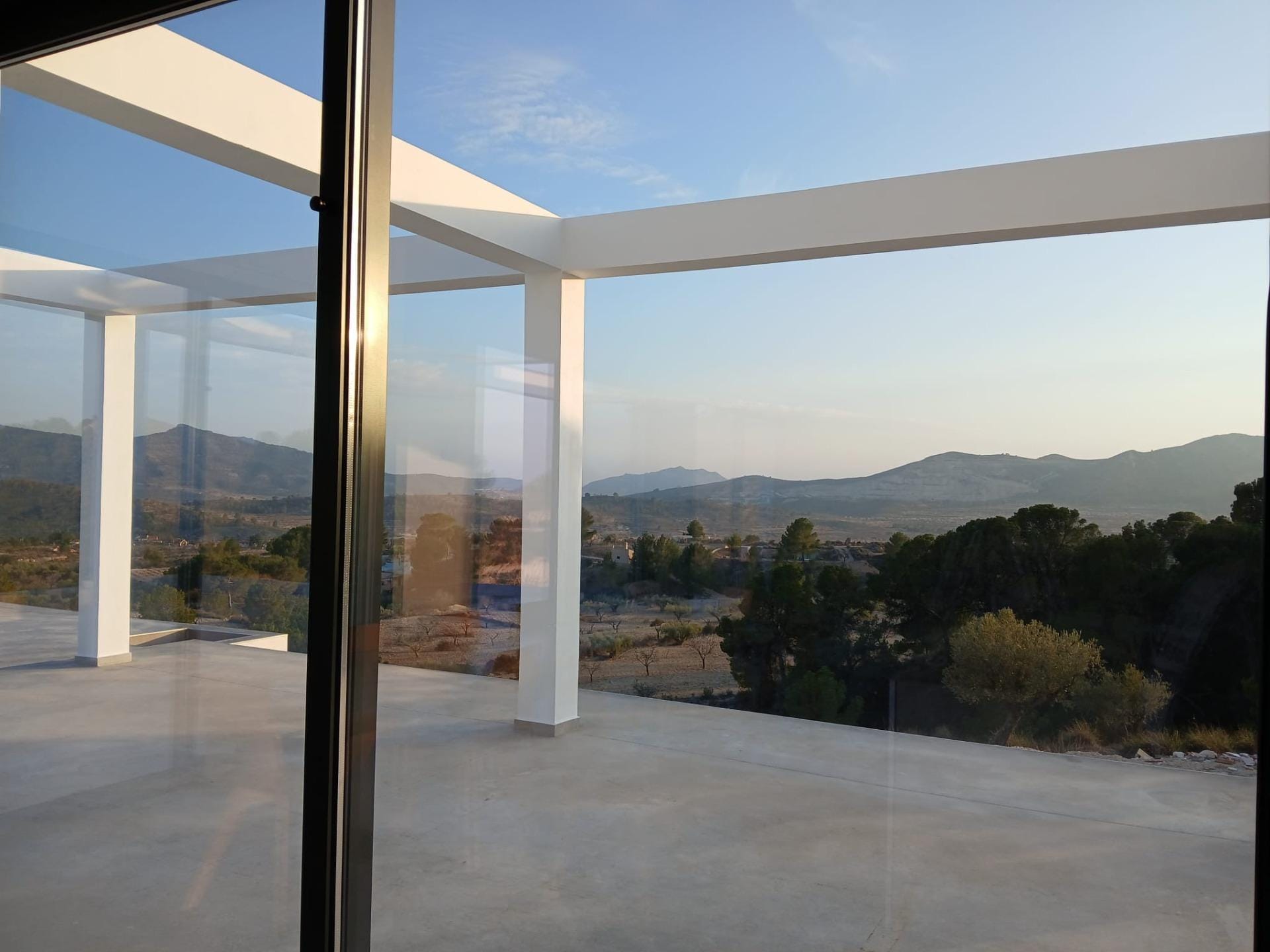 Custom-Built-New-Villas-in-Pinoso-Alicante-Spacious-Homes-in-Natural-Surroundings-10 View through sliding doors towards a terrace and countryside in Pinoso, Alicante