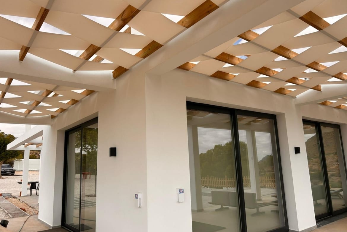 Villa corner with sliding glass doors beneath terrace shade panels in Pinoso, Alicante