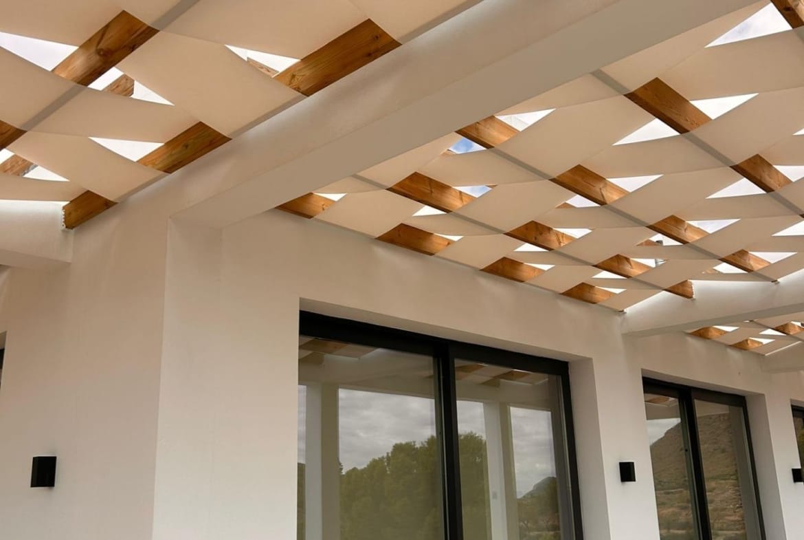 Shaded terrace and sliding glass doors along a villa facade in Pinoso, Alicante