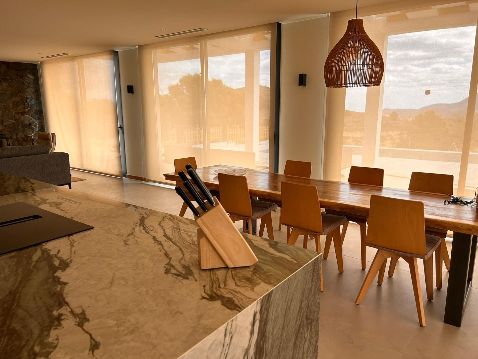 Custom-Built-New-Villas-in-Pinoso-Alicante-Spacious-Homes-in-Natural-Surroundings-16 Kitchen island and dining table beside sunlit glass doors in Pinoso, Alicante
