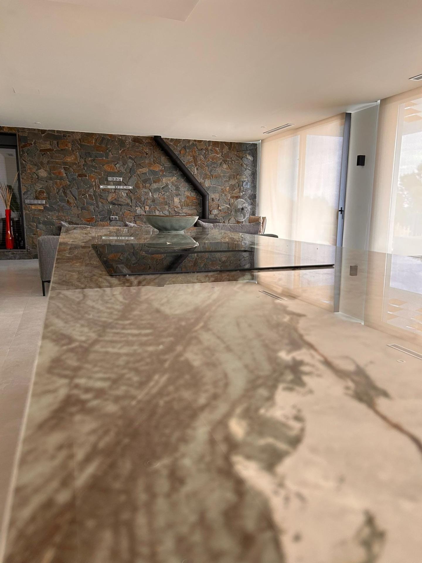 Custom-Built-New-Villas-in-Pinoso-Alicante-Spacious-Homes-in-Natural-Surroundings-18 Stone-pattern kitchen island facing the living room in Pinoso, Alicante