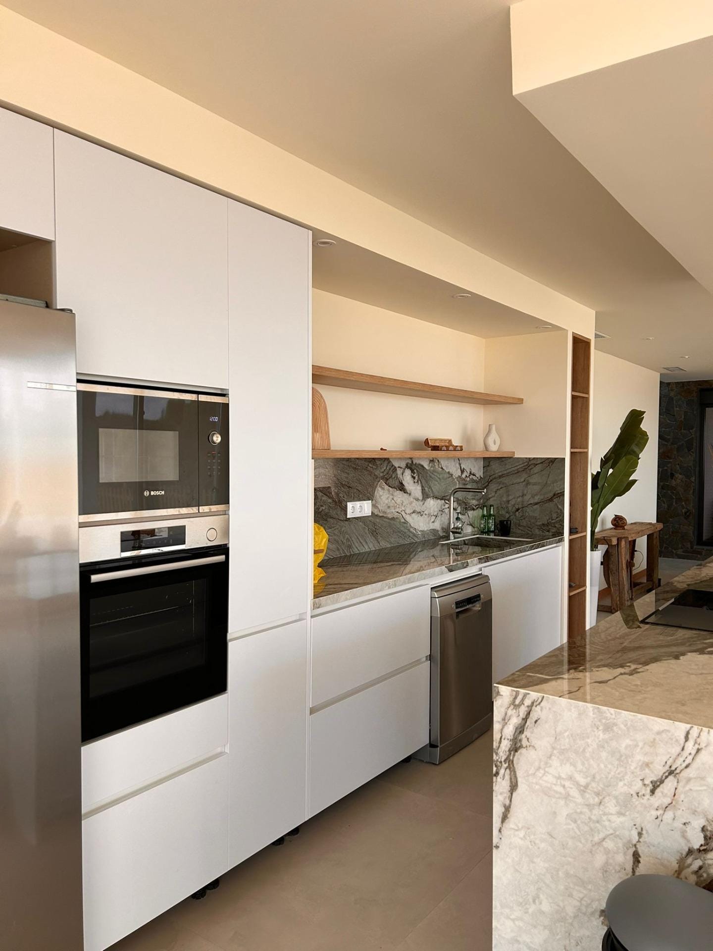 Custom-Built-New-Villas-in-Pinoso-Alicante-Spacious-Homes-in-Natural-Surroundings-20 Fitted kitchen cabinets and worktop beside a stone-pattern island in Pinoso, Alicante