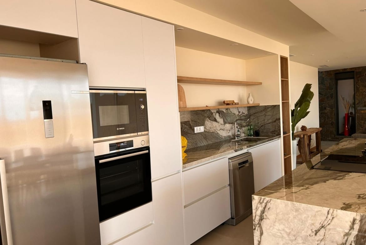 Kitchen appliances and shelving beside an island worktop in Pinoso, Alicante