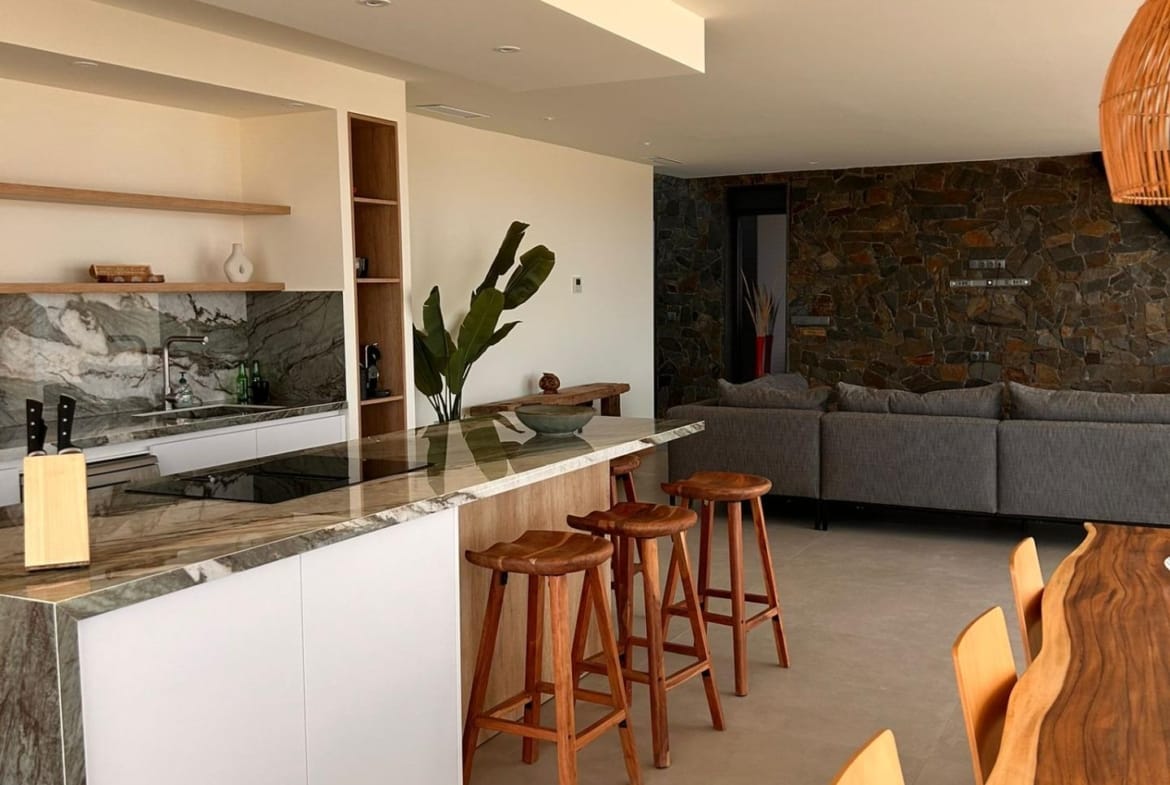 Open-plan kitchen island, breakfast stools and living room in Pinoso, Alicante