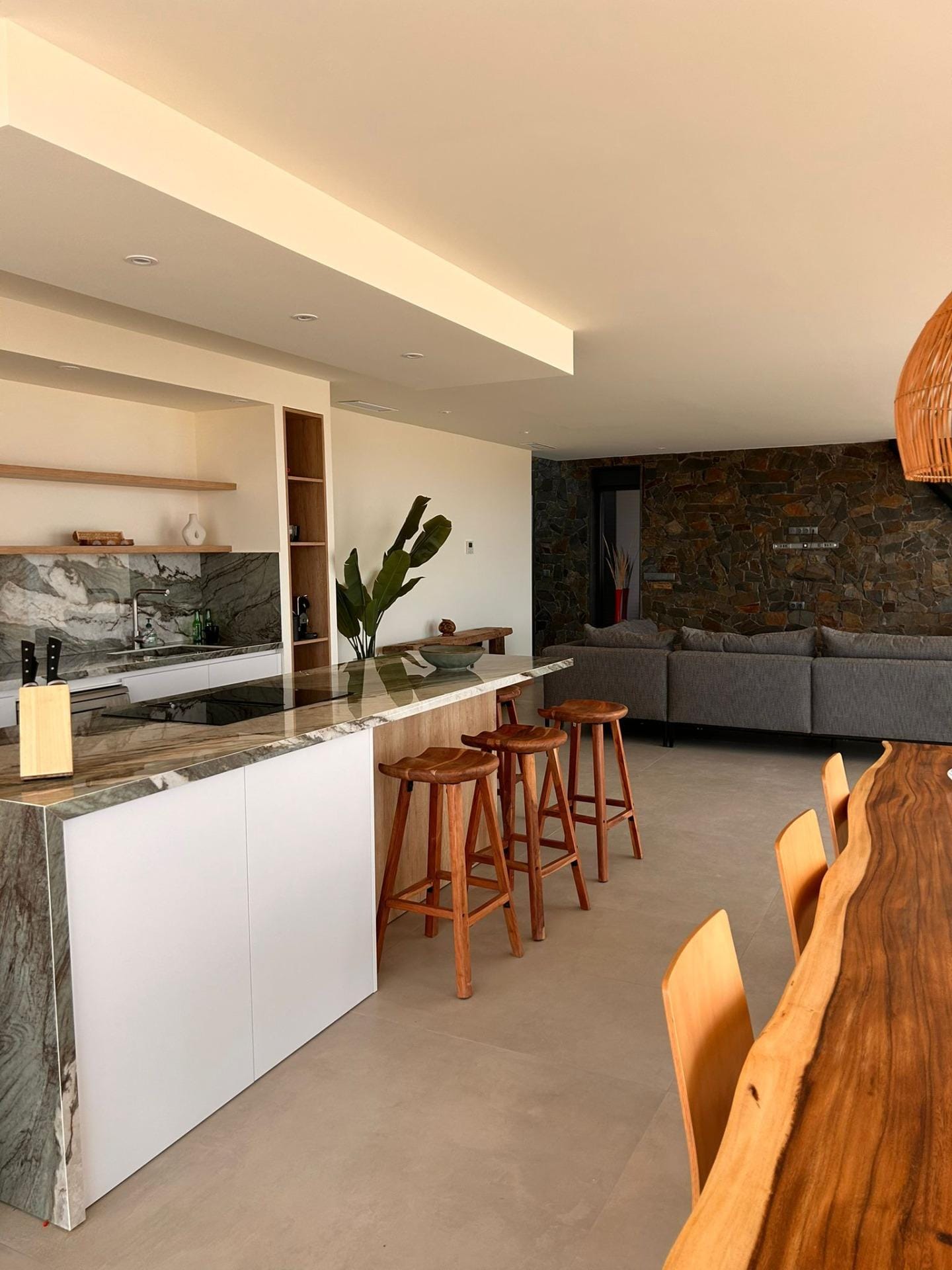 Custom-Built-New-Villas-in-Pinoso-Alicante-Spacious-Homes-in-Natural-Surroundings-22 Open-plan kitchen island, breakfast stools and living room in Pinoso, Alicante