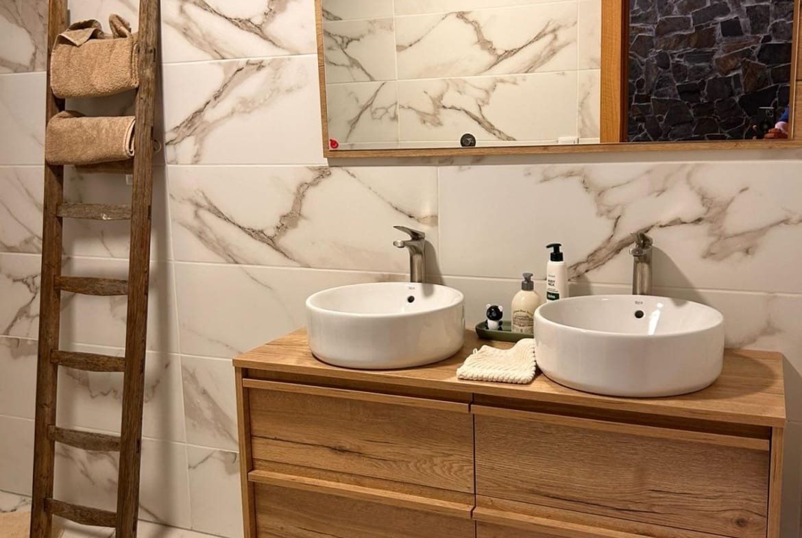 Bathroom with twin countertop basins and a wooden vanity in Pinoso, Alicante