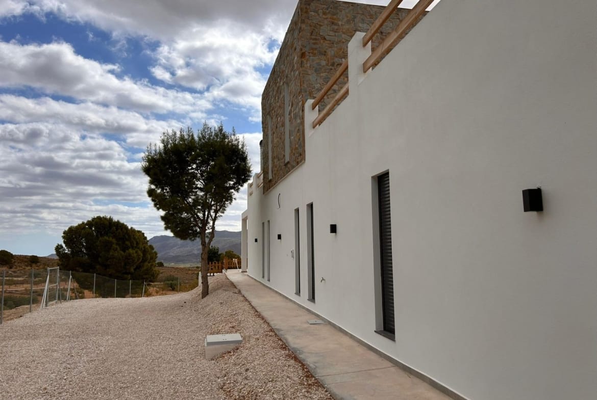 Villa side facade, gravel garden and countryside setting in Pinoso, Alicante