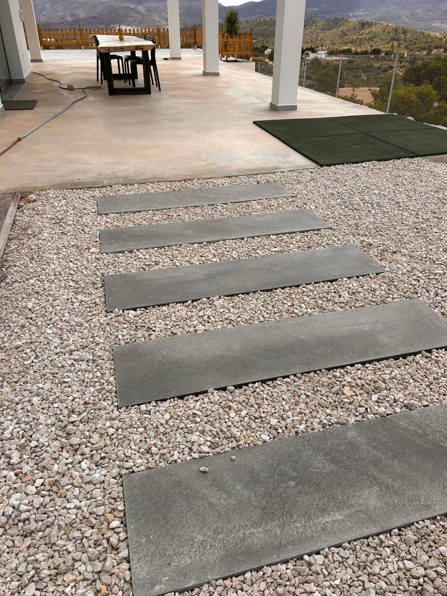 Custom-Built-New-Villas-in-Pinoso-Alicante-Spacious-Homes-in-Natural-Surroundings-30 Stepping stones through gravel towards a covered dining terrace in Pinoso, Alicante