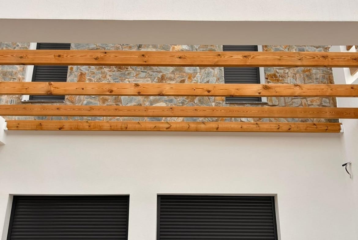 Upper terrace railing above dark villa window shutters in Pinoso, Alicante
