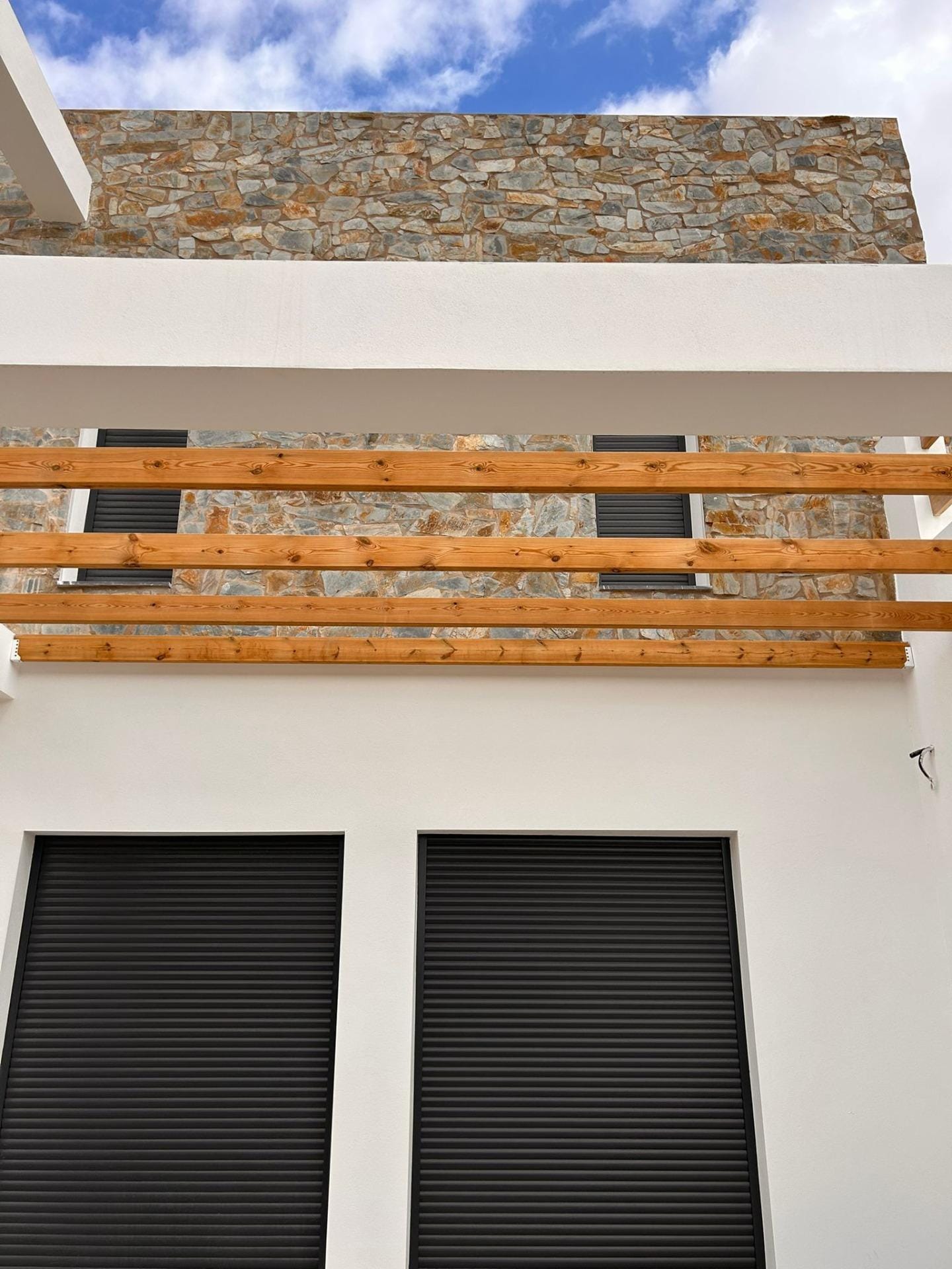 Custom-Built-New-Villas-in-Pinoso-Alicante-Spacious-Homes-in-Natural-Surroundings-32 Upper terrace railing above dark villa window shutters in Pinoso, Alicante