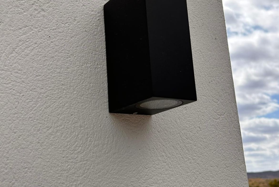 Black exterior wall light on a white villa wall in Pinoso, Alicante