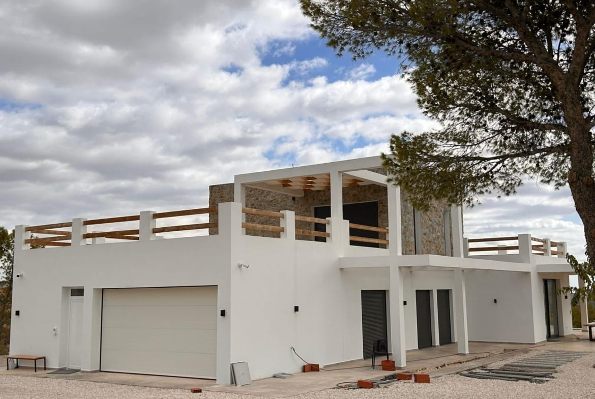 Villa facade and closed garage beside a gravel forecourt in Pinoso, Alicante