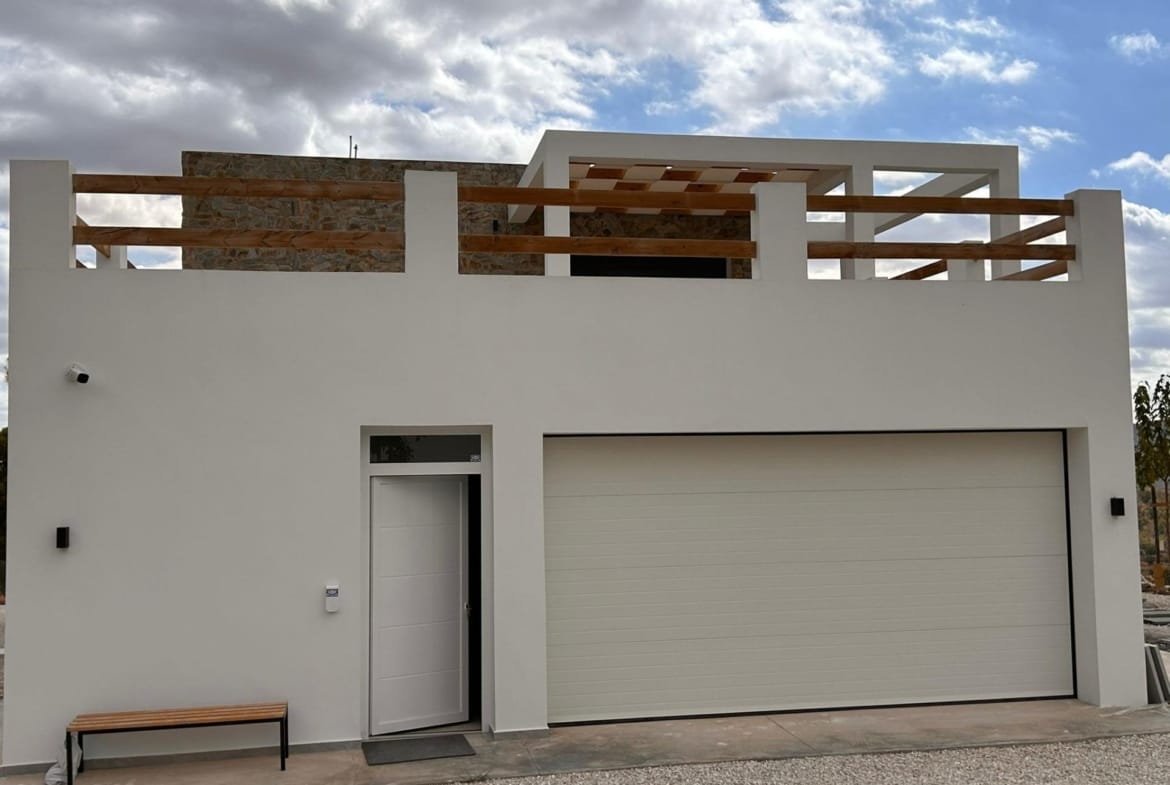 Closed garage and entrance door on a white villa facade in Pinoso, Alicante