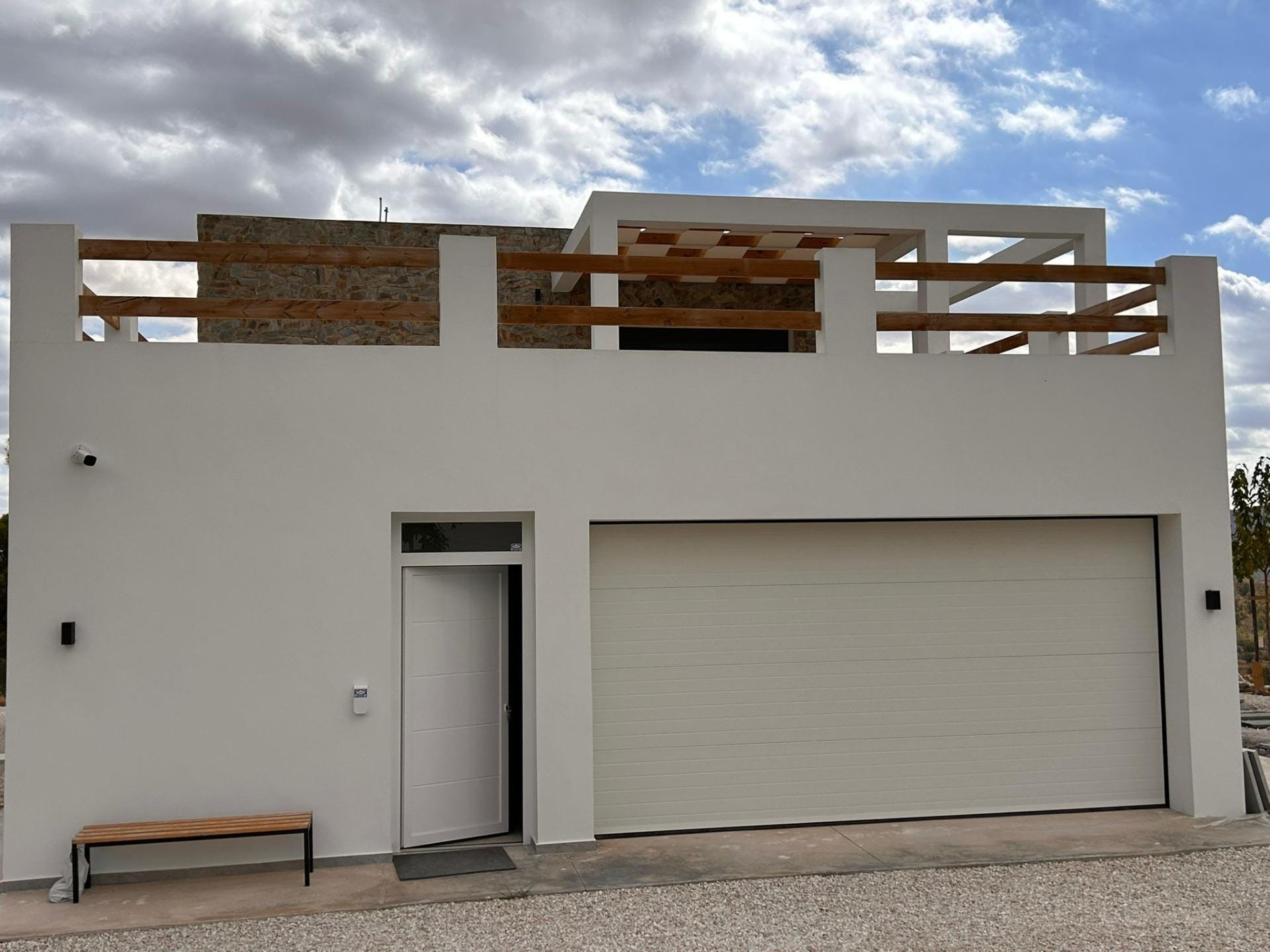 Custom-Built-New-Villas-in-Pinoso-Alicante-Spacious-Homes-in-Natural-Surroundings-40 Closed garage and entrance door on a white villa facade in Pinoso, Alicante