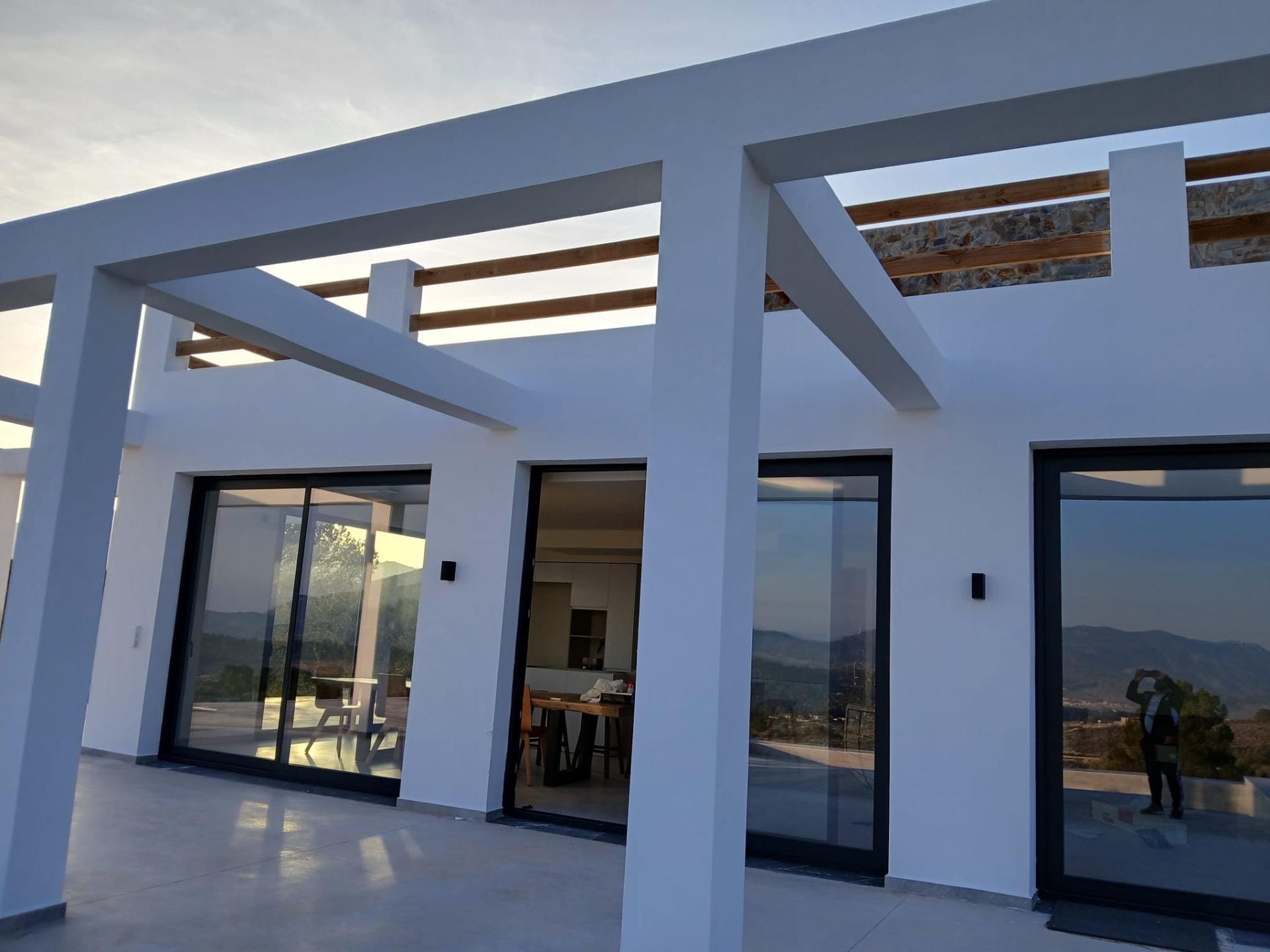 Custom-Built-New-Villas-in-Pinoso-Alicante-Spacious-Homes-in-Natural-Surroundings-5 Terrace beams and sliding glass doors on a white villa facade in Pinoso, Alicante